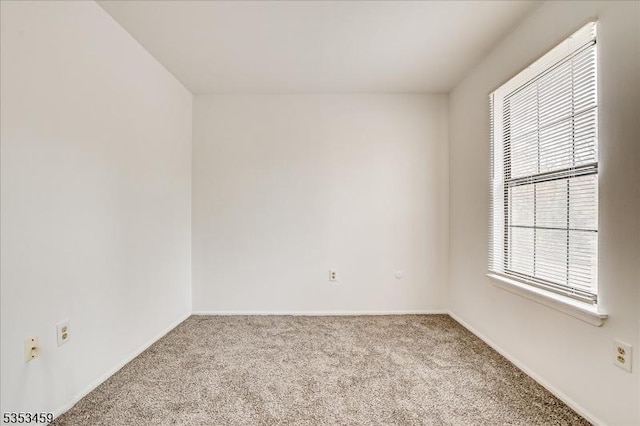 carpeted spare room with baseboards
