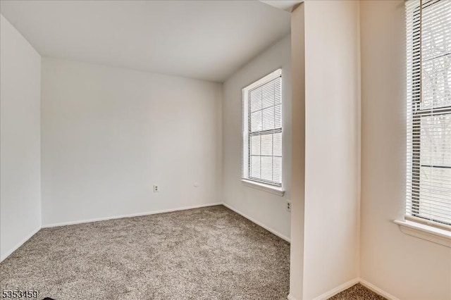 carpeted spare room with baseboards