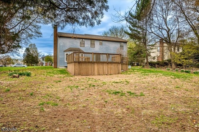 back of property with a wooden deck and a chimney