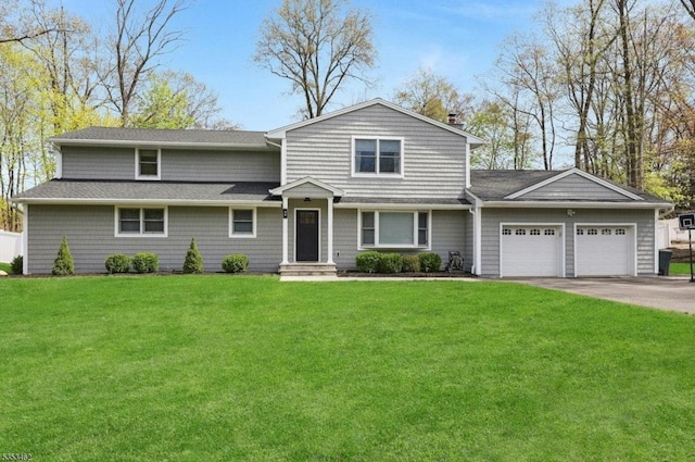 traditional-style home with a shingled roof, an attached garage, a front yard, a chimney, and driveway