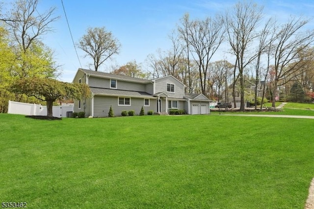 traditional-style home with fence, an attached garage, and a front yard