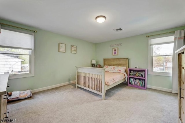 carpeted bedroom featuring baseboards and visible vents