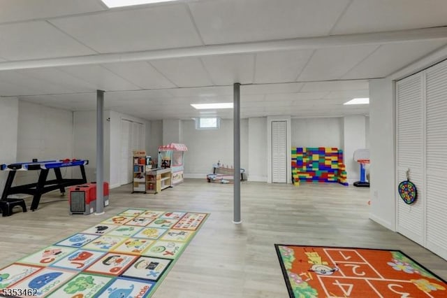 recreation room featuring shuffleboard, baseboards, and wood finished floors