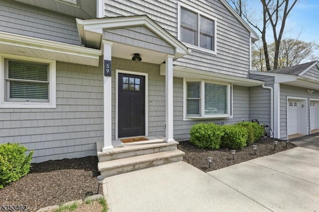 entrance to property with concrete driveway and an attached garage