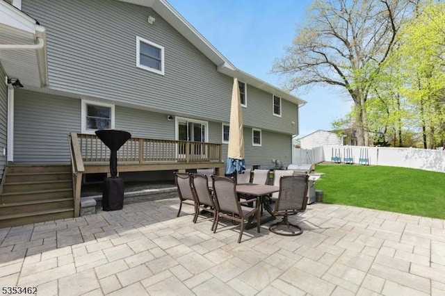view of patio featuring fence, a wooden deck, and outdoor dining space