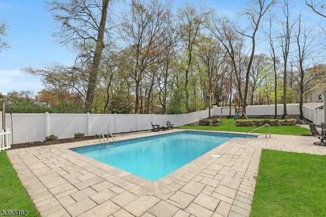 view of swimming pool with a fenced backyard, a fenced in pool, a patio, and a yard