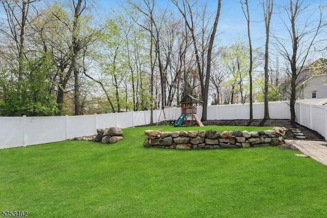 view of yard featuring a fenced backyard and a playground