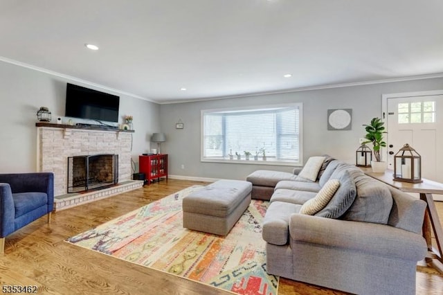 living room featuring crown molding, recessed lighting, wood finished floors, and a fireplace
