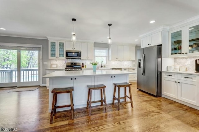kitchen with light countertops, white cabinetry, a sink, appliances with stainless steel finishes, and backsplash