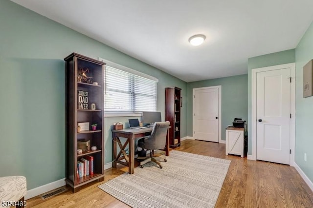 office area featuring baseboards, visible vents, and light wood-style flooring