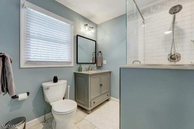 bathroom with tile patterned flooring, vanity, toilet, baseboards, and a tile shower