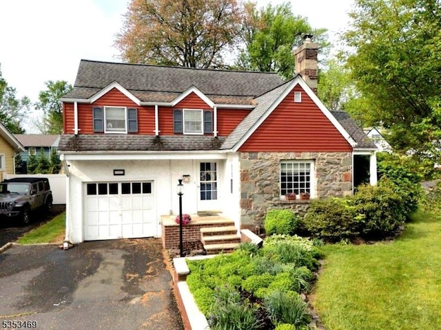 view of front of property with an attached garage, a shingled roof, driveway, and a chimney