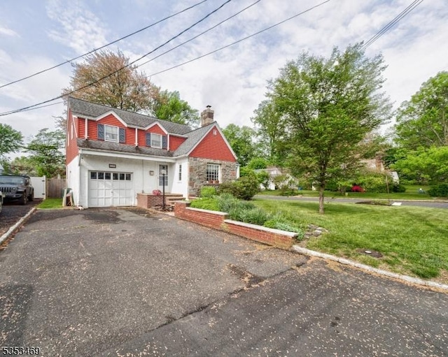 view of front of house featuring an attached garage, stone siding, driveway, a front lawn, and a chimney