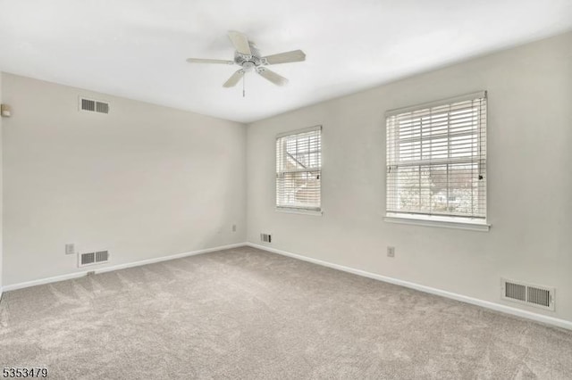 carpeted spare room with baseboards and visible vents