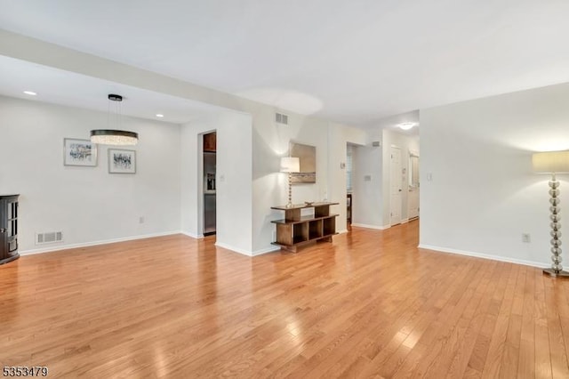 unfurnished living room with recessed lighting, visible vents, baseboards, and light wood-style floors