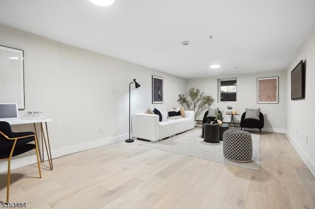 living room featuring baseboards and light wood-style flooring