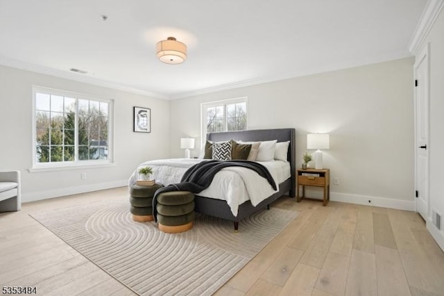 bedroom featuring crown molding, baseboards, light wood finished floors, and visible vents