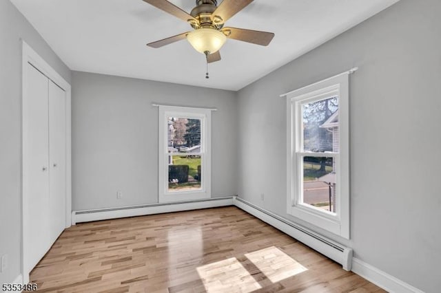 97 Belvidere Ave, Oxford Twp, NJ 07863 - unfurnished bedroom with baseboard heating, wood finished floors, a baseboard heating unit, and multiple windows