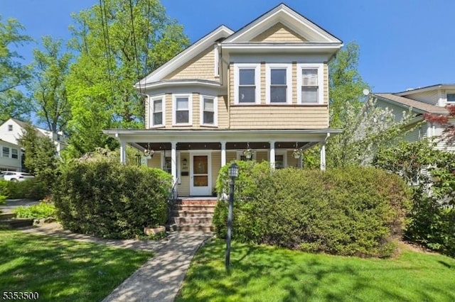 victorian home with covered porch and a front lawn