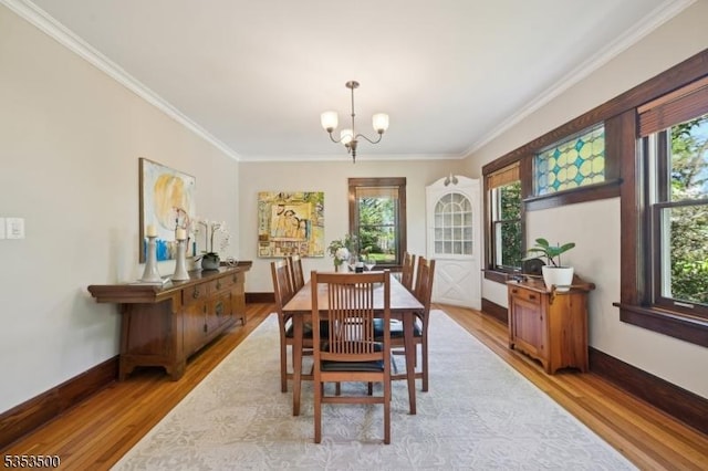 dining space featuring ornamental molding, wood finished floors, and a notable chandelier