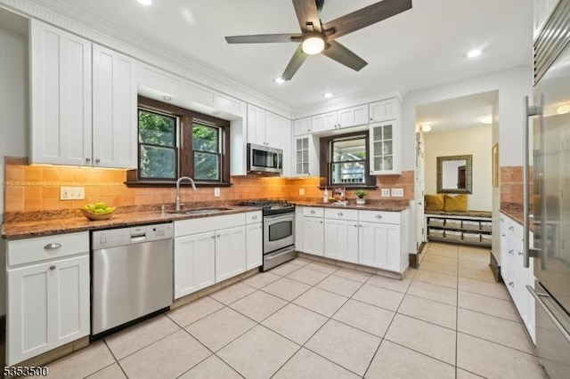 kitchen with a sink, tasteful backsplash, stainless steel appliances, and white cabinetry