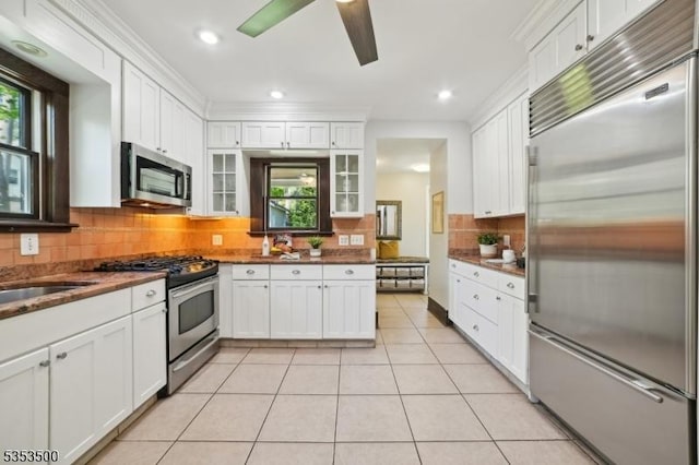kitchen with appliances with stainless steel finishes, tasteful backsplash, white cabinets, and a wealth of natural light