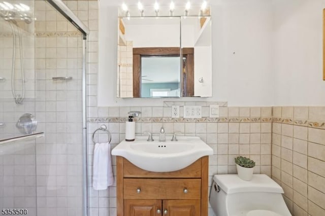 full bathroom featuring vanity, a shower stall, toilet, and tile walls