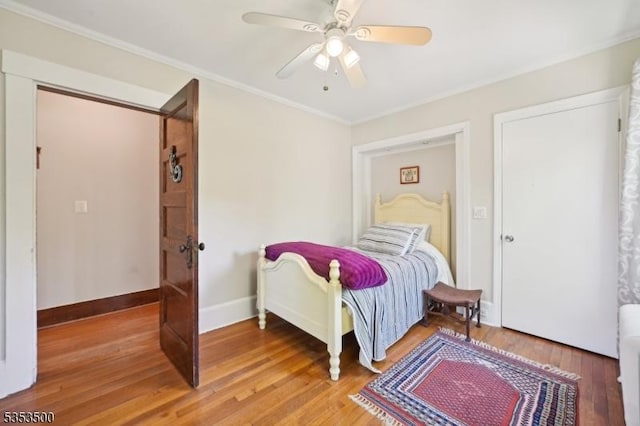 bedroom with light wood-style floors, baseboards, ornamental molding, and a ceiling fan