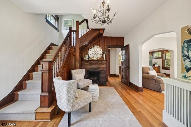 living room featuring light wood-type flooring, stairs, and a chandelier