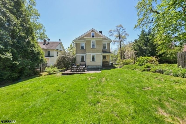 rear view of property featuring a patio and a yard