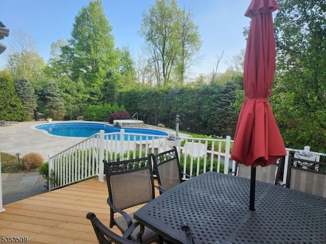 deck featuring a patio, outdoor dining space, and an outdoor pool