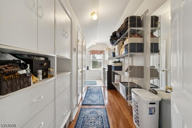 walk in closet with wood finished floors and lofted ceiling