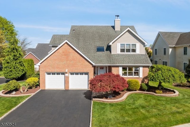 traditional home with aphalt driveway, a garage, brick siding, a front yard, and a chimney