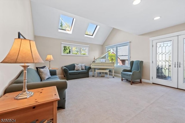 carpeted living area with recessed lighting, baseboards, french doors, and lofted ceiling with skylight