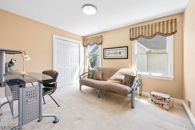 carpeted office space featuring baseboards and visible vents