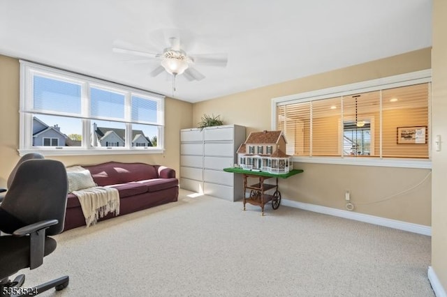office area featuring baseboards, a ceiling fan, and carpet