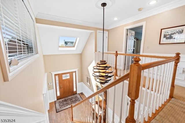 foyer with crown molding, a wainscoted wall, a skylight, and recessed lighting