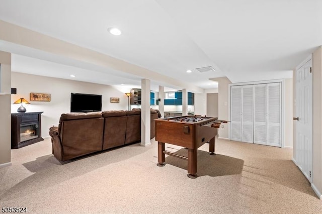 game room with light carpet, a glass covered fireplace, recessed lighting, baseboards, and visible vents