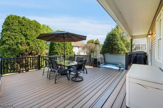 deck featuring outdoor dining space and a grill