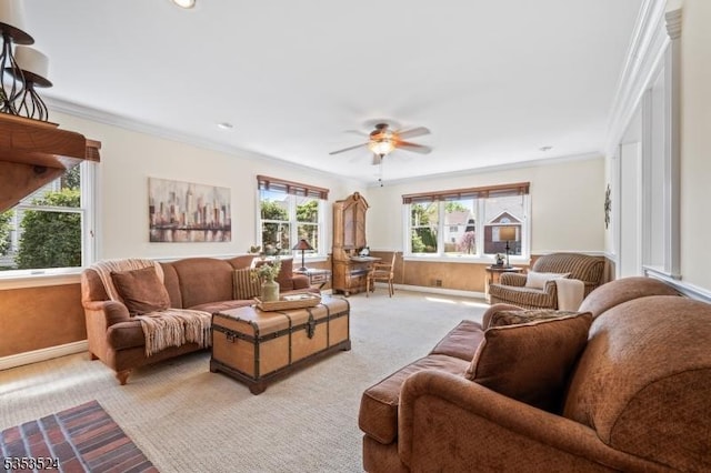 living area featuring plenty of natural light, a ceiling fan, crown molding, and light colored carpet