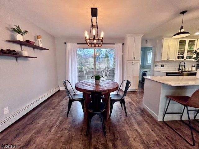 dining space featuring baseboards, a notable chandelier, dark wood-type flooring, and a baseboard radiator