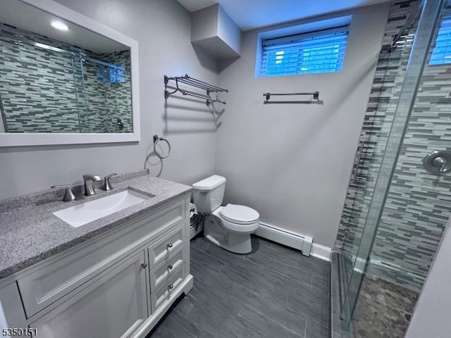 full bath with a shower stall, baseboard heating, toilet, vanity, and baseboards
