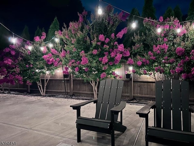 patio at twilight with a fenced backyard