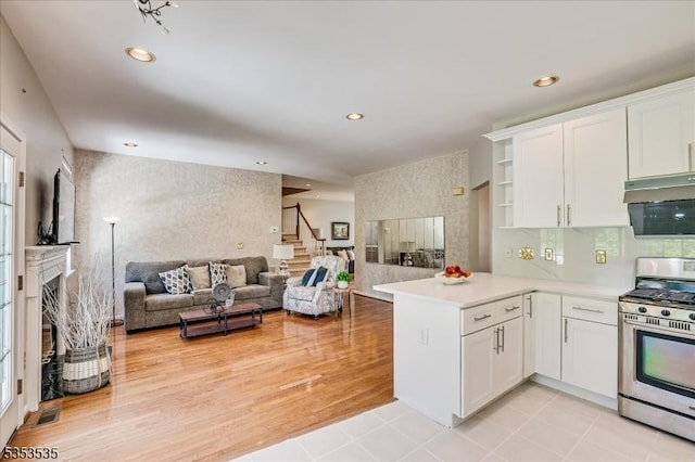 35 Hansom Rd, Bernards Twp, NJ 07920 - kitchen featuring a multi sided fireplace, gas stove, white cabinets, a peninsula, and open floor plan