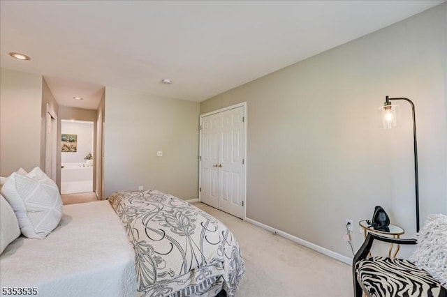 bedroom with a closet, light carpet, baseboards, recessed lighting, and connected bathroom
