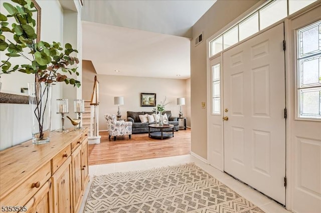 entryway with visible vents, baseboards, plenty of natural light, and light tile patterned floors