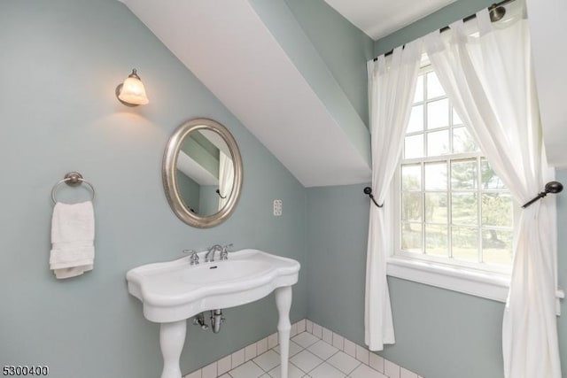bathroom with tile patterned floors and vaulted ceiling