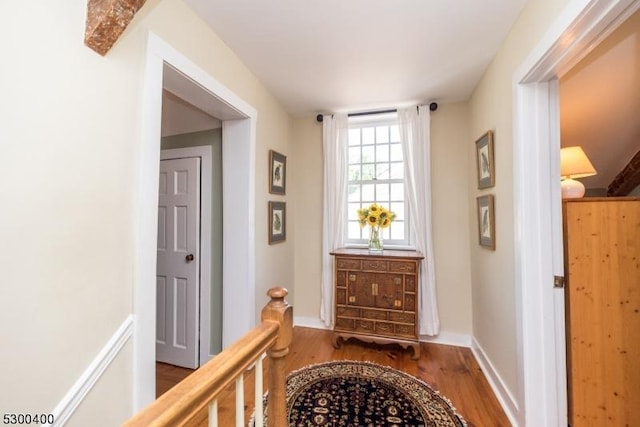 corridor featuring baseboards and wood finished floors