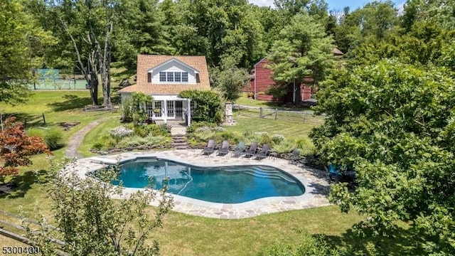 outdoor pool with fence, french doors, a diving board, and a lawn