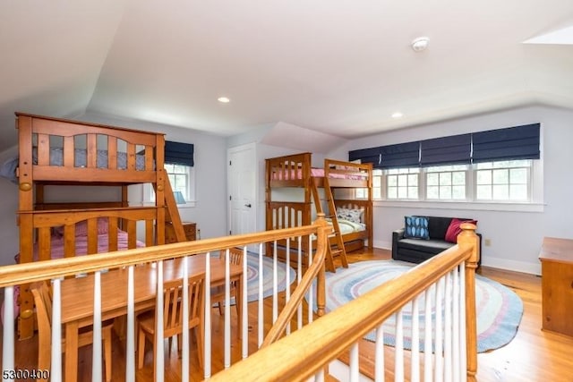 interior space with baseboards, wood finished floors, and vaulted ceiling